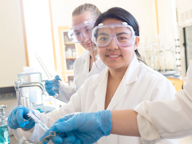 Student wears safety googles while working in a lab