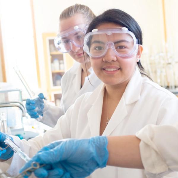 Student wears safety googles while working in a lab